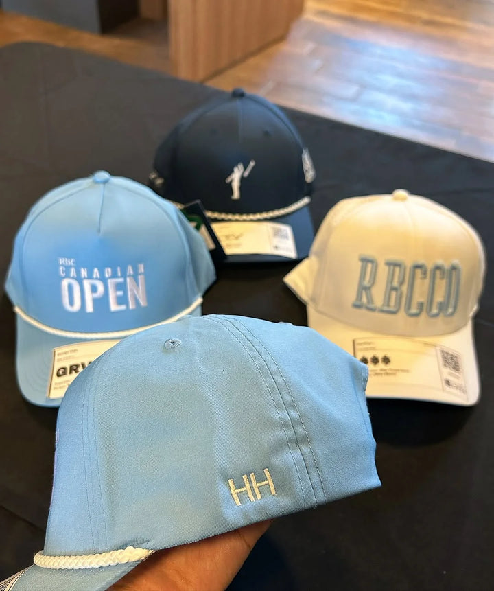 Caps with freshly embroidered initials at a live hat bar at a golf tournament