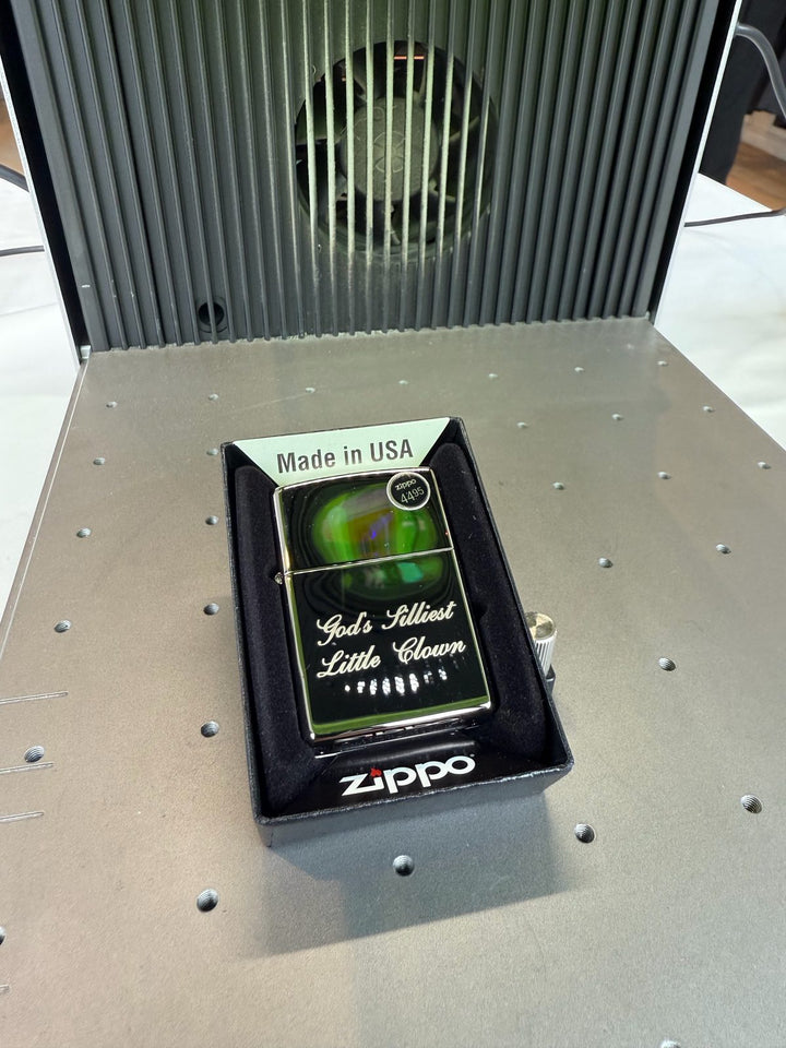 Boxed lighter with script text laser-engraved on its front, sitting on the laser bed