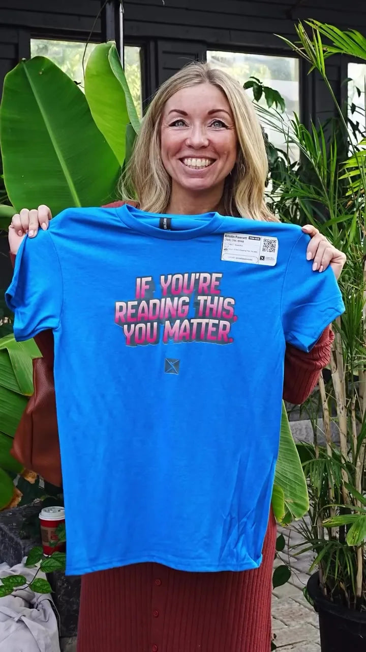 A guest holding up a T-shirt printed live at a community event