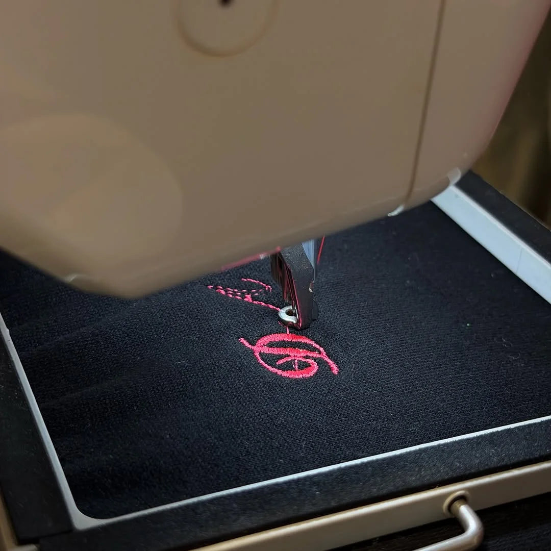 Pink lettering stitching onto fleece