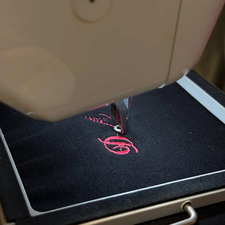 Pink lettering stitching onto fleece