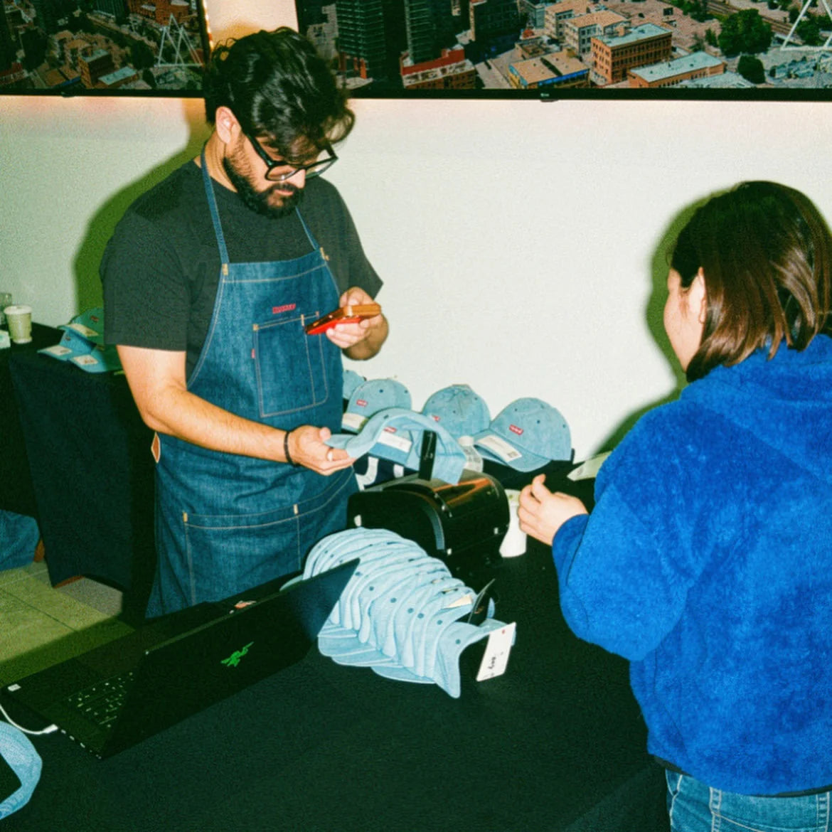 Our team handing a personalized Levi’s cap to a guest