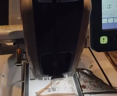 A patterned textile beneath an embroidery-machine needle
