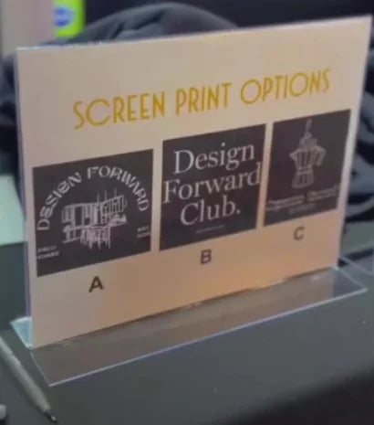 A printed design-options card on the merchandise-station table at the Deco Homes event.