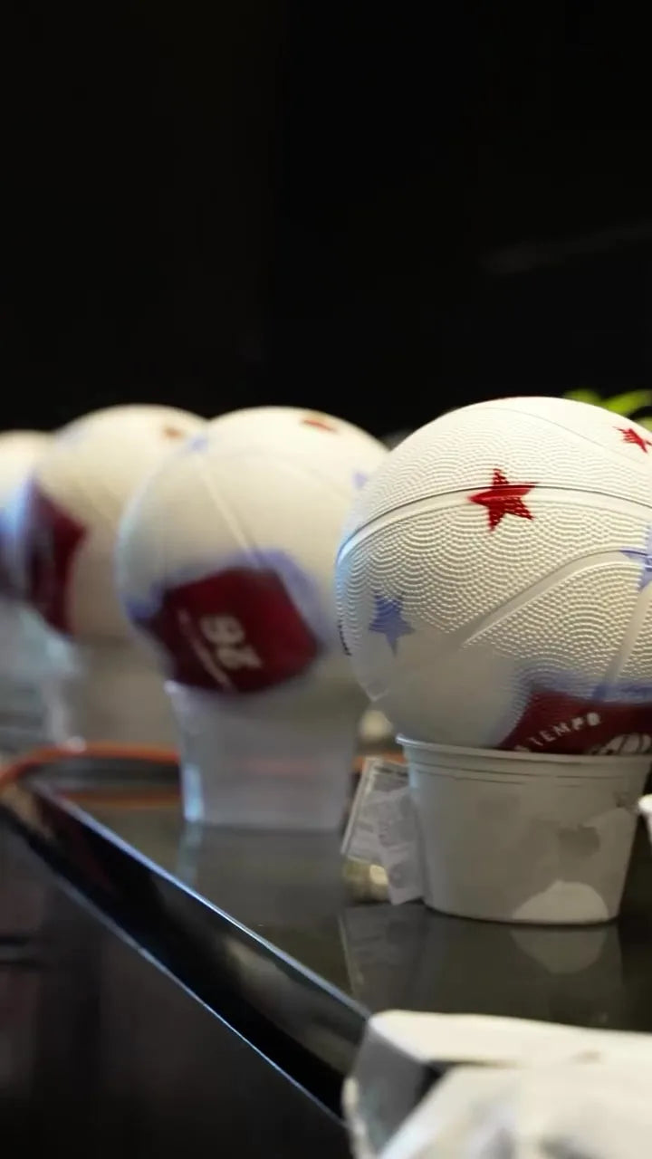 Finished Toronto Tempo basketballs arranged on holders.