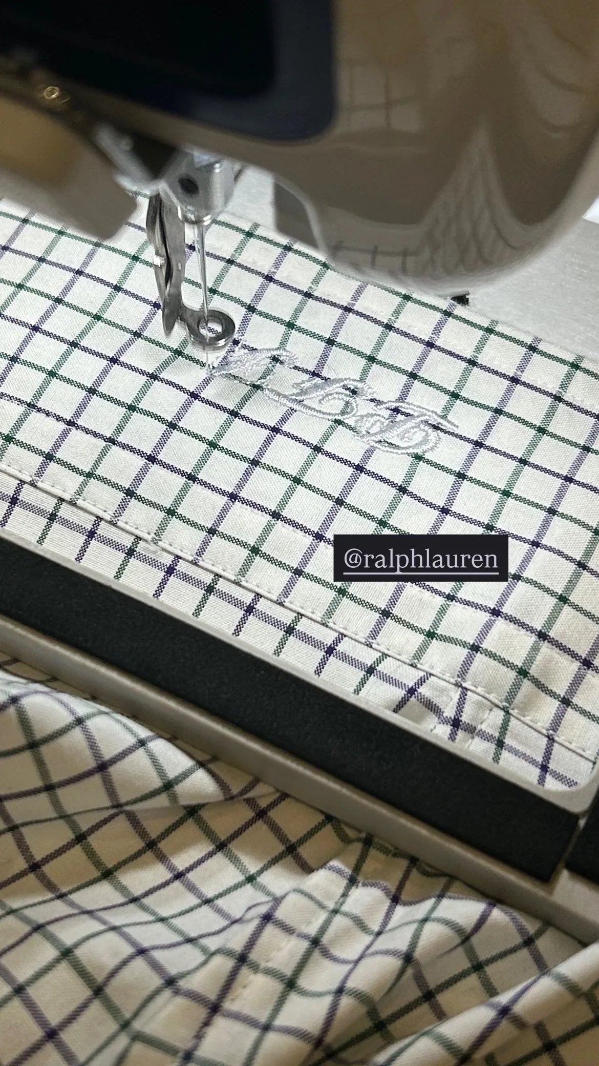 An embroidery machine stitching initials onto checked Ralph Lauren fabric.