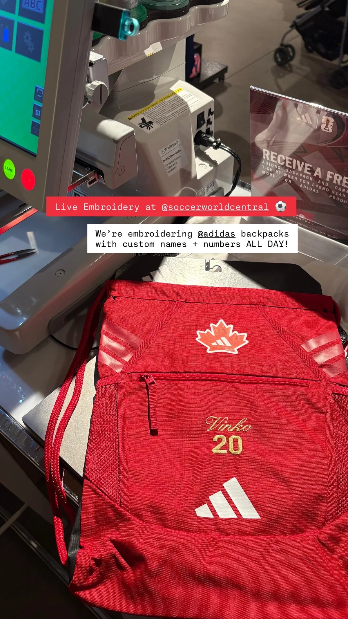 An adidas backpack beneath the embroidery machine at Soccer World Central.