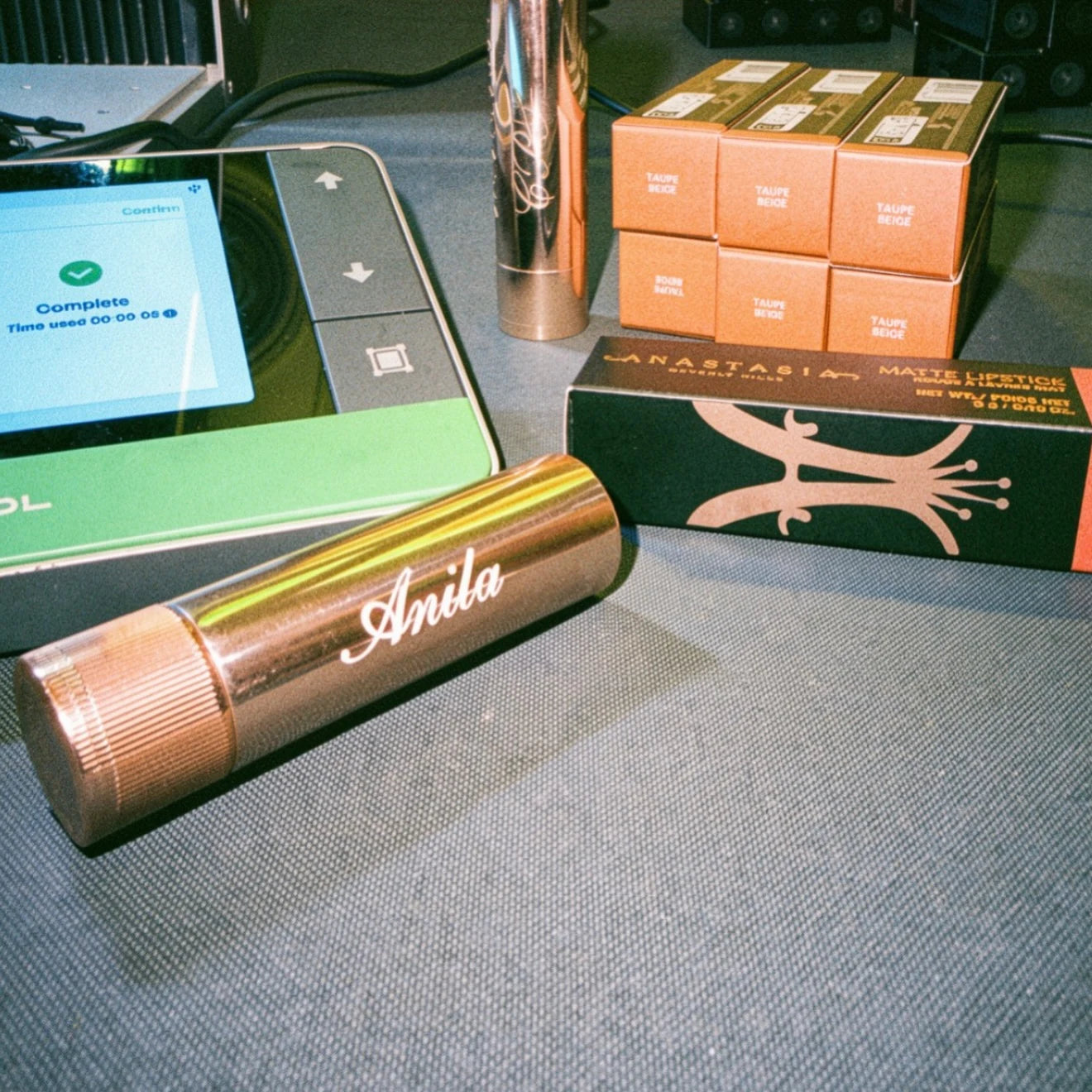 Personalized metallic lipstick cases beside a laser controller.